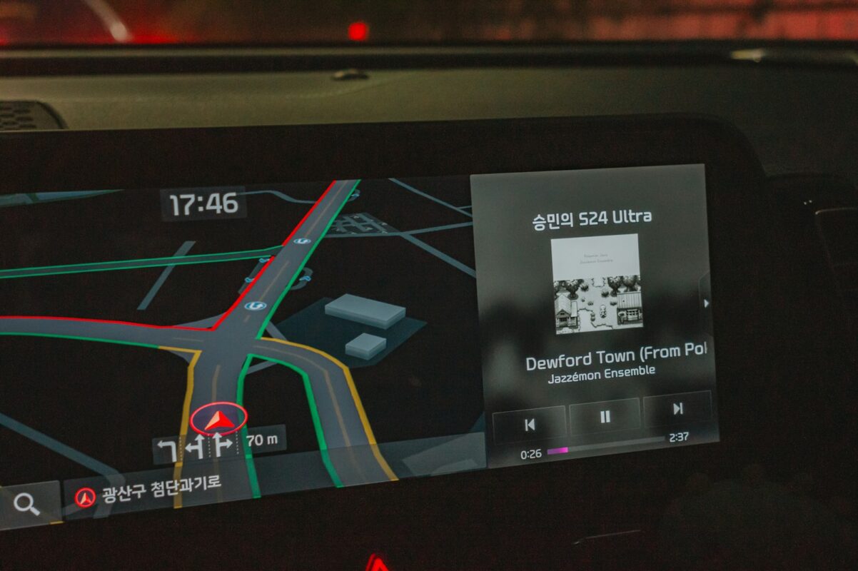 Car touchscreen head unit showing navigation and music